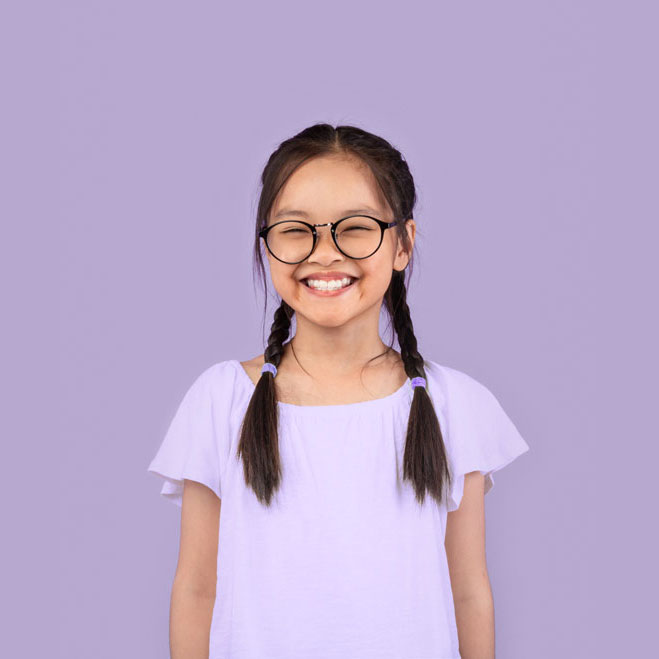 Ein fröhliches Kind mit Brille lächelt in die Kamera